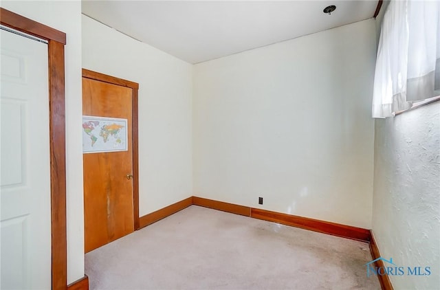 spare room with carpet and baseboards