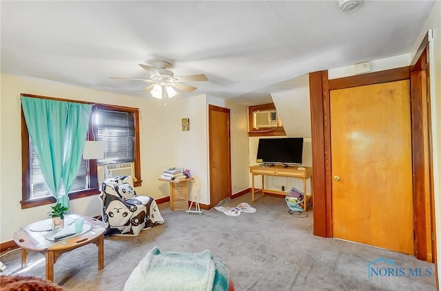 living area featuring baseboards, a wall mounted AC, a ceiling fan, and carpet floors