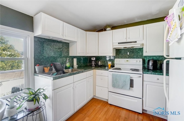 kitchen featuring white cabinetry, white appliances, under cabinet range hood, and a sink