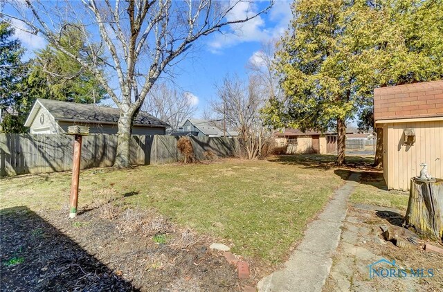 view of yard with an outdoor structure and fence