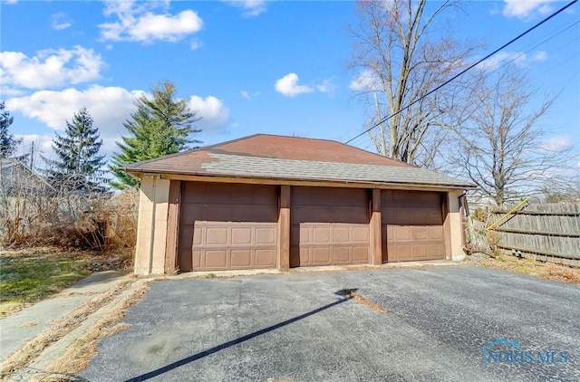 detached garage featuring fence