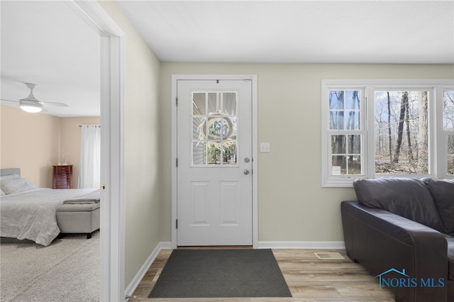 entrance foyer featuring light wood-style flooring, a ceiling fan, and baseboards