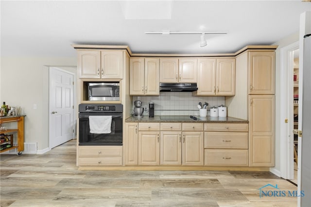 kitchen featuring black appliances, light brown cabinets, under cabinet range hood, tasteful backsplash, and light wood-style floors