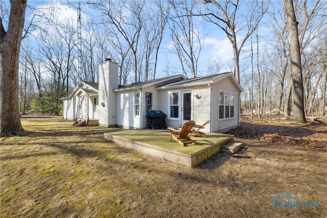 rear view of house with a lawn and a chimney