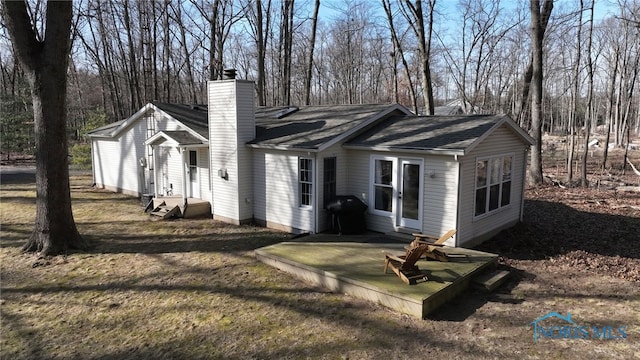 view of front facade with entry steps, a front yard, and a chimney