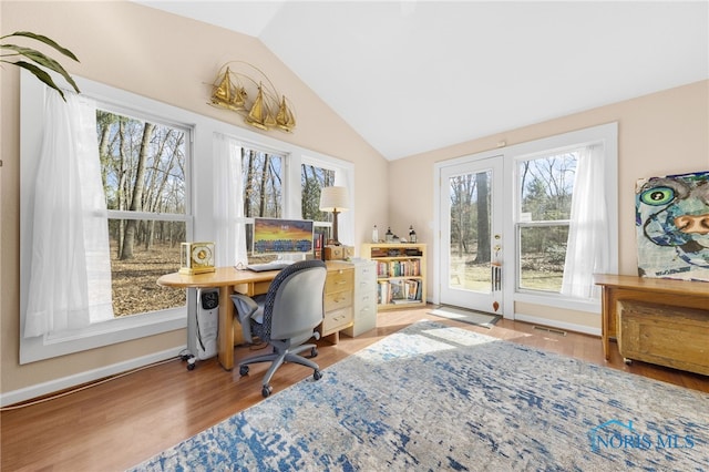 office with a wealth of natural light, visible vents, lofted ceiling, and wood finished floors