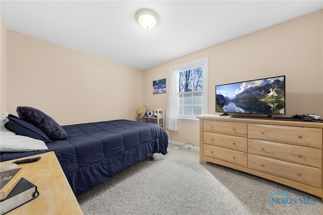 bedroom featuring baseboards and light carpet