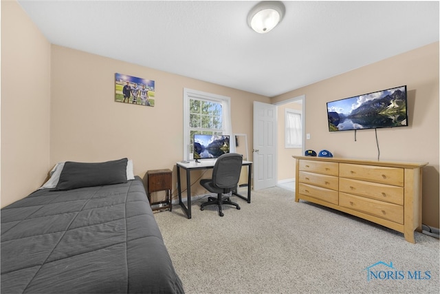 bedroom featuring baseboards and light carpet