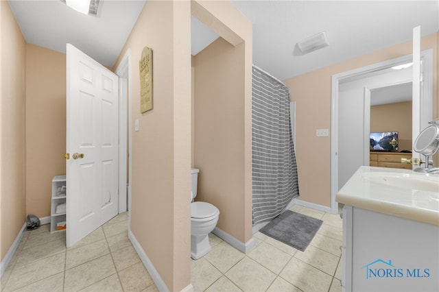 bathroom with tile patterned floors, toilet, a shower with shower curtain, baseboards, and vanity