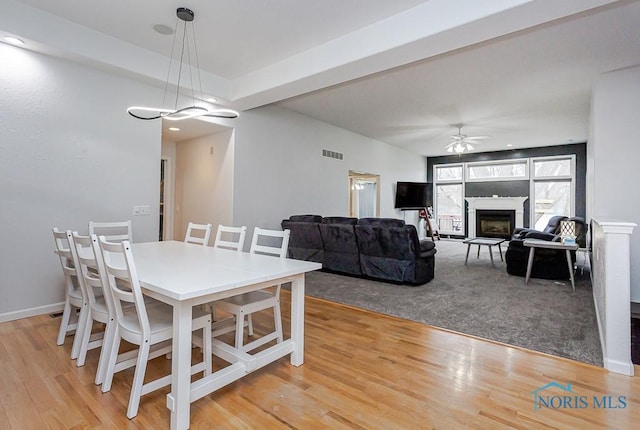 dining room featuring visible vents, baseboards, light wood-style floors, and ceiling fan