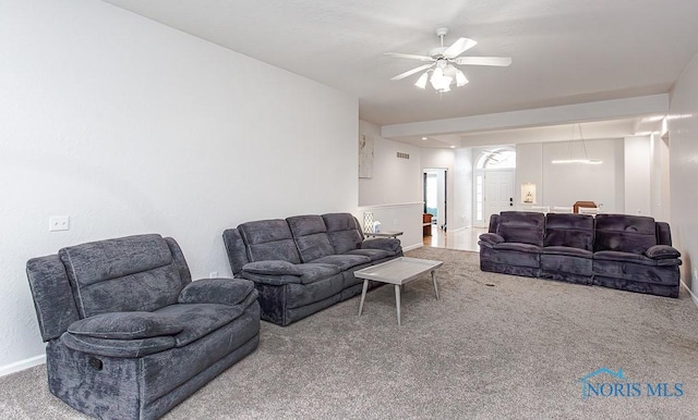 living area featuring carpet flooring, baseboards, and ceiling fan