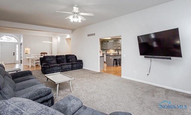 living area featuring visible vents, carpet floors, baseboards, and a ceiling fan