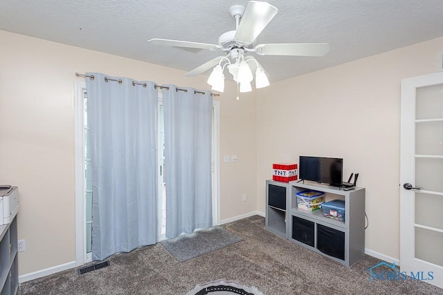 game room featuring visible vents, baseboards, ceiling fan, carpet floors, and a textured ceiling