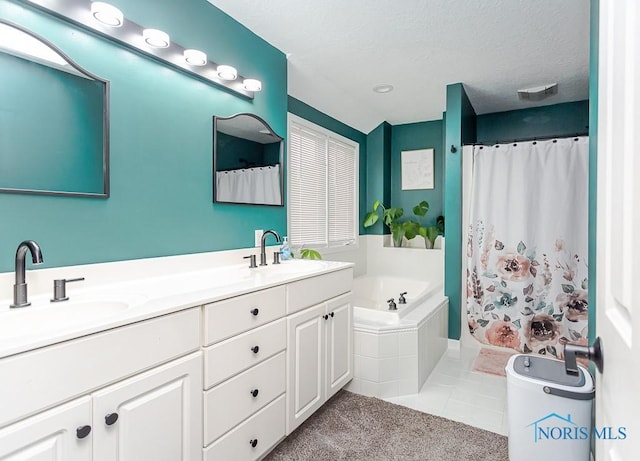 full bathroom featuring a sink, a textured ceiling, a bath, and double vanity