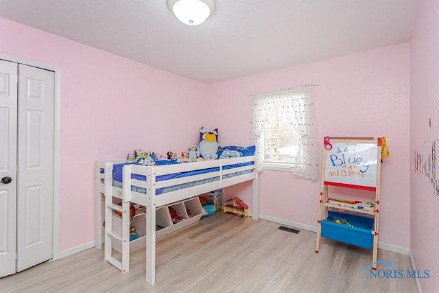 bedroom featuring visible vents, baseboards, and wood finished floors