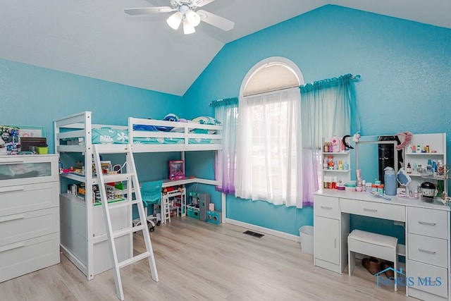 bedroom featuring visible vents, baseboards, ceiling fan, light wood-type flooring, and vaulted ceiling