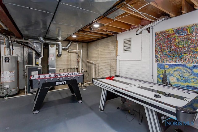 recreation room featuring concrete flooring and gas water heater