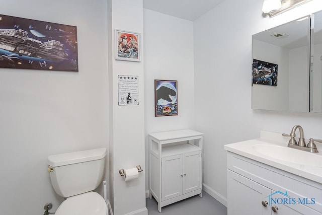 half bathroom with toilet, visible vents, baseboards, and vanity