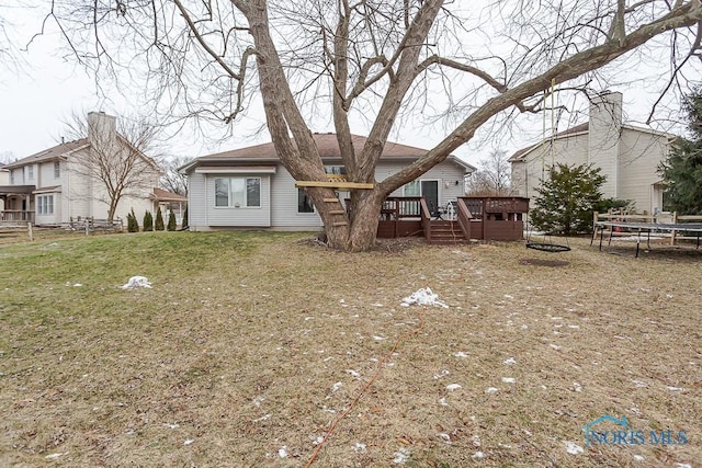 rear view of house with a deck and a lawn