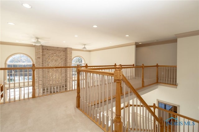 corridor with an upstairs landing, a healthy amount of sunlight, and ornamental molding