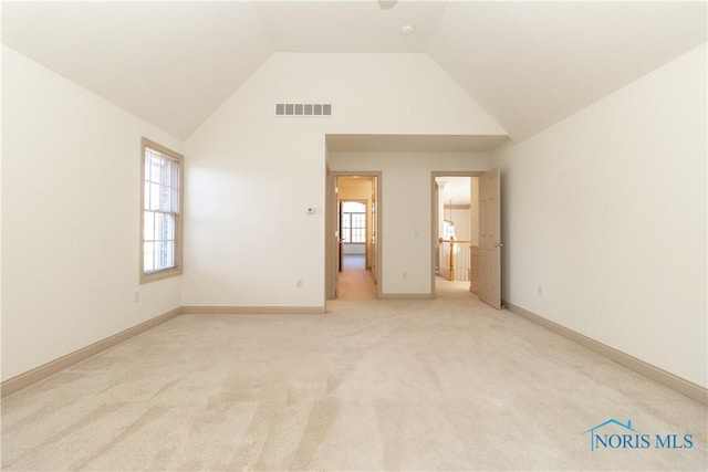 unfurnished bedroom with light carpet, visible vents, high vaulted ceiling, and baseboards