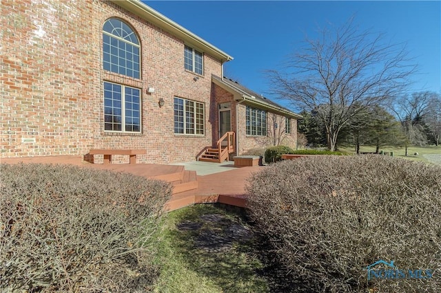 back of house with entry steps and brick siding