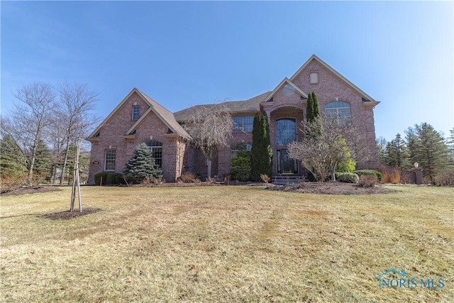 view of front of house featuring brick siding and a front lawn