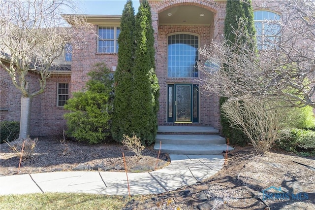 doorway to property with brick siding