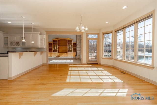 interior space with visible vents, recessed lighting, light wood finished floors, baseboards, and a chandelier