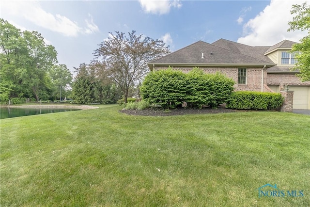 2436 Tiffany Village Blvd, Sylvania, OH 43560 - view of green lawn with an attached garage and a water view