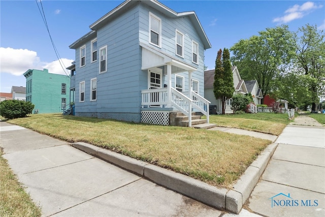 view of side of home featuring crawl space, covered porch, and a lawn