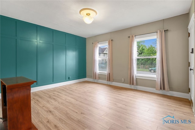 unfurnished room featuring baseboards and light wood finished floors