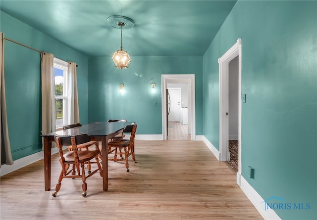 dining area featuring light wood-style flooring and baseboards