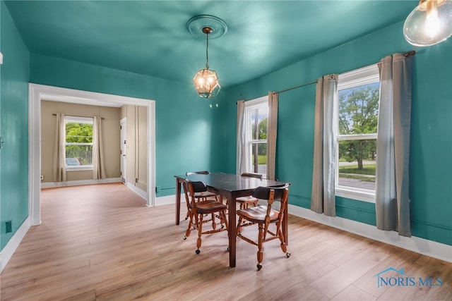 dining space with baseboards and wood finished floors