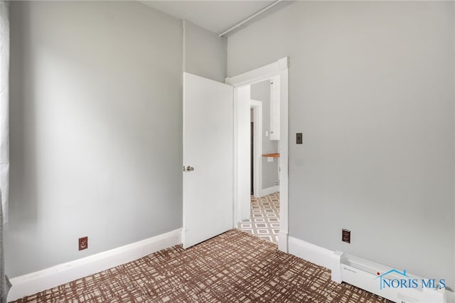 unfurnished room with baseboards