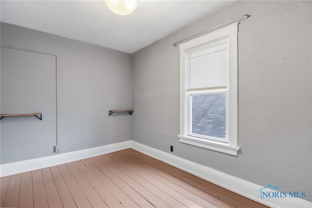 empty room featuring wood finished floors and baseboards