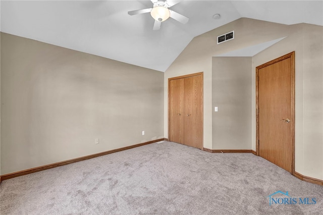 unfurnished bedroom featuring visible vents, a closet, carpet, ceiling fan, and vaulted ceiling