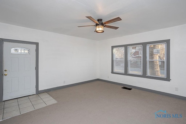 interior space featuring baseboards, carpet floors, and ceiling fan