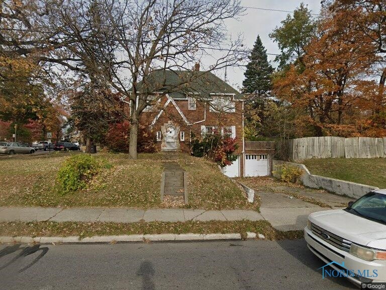 view of front of home with fence, a garage, and a chimney