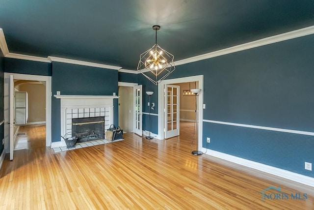 121 Eagle Point Dr, Rossford, OH 43460 - unfurnished living room featuring a chandelier, a fireplace, crown molding, wood finished floors, and baseboards