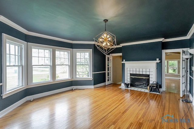 121 Eagle Point Dr, Rossford, OH 43460 - unfurnished living room with a chandelier, wood finished floors, crown molding, a tiled fireplace, and baseboards
