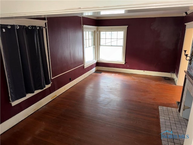 unfurnished room with baseboards and wood finished floors