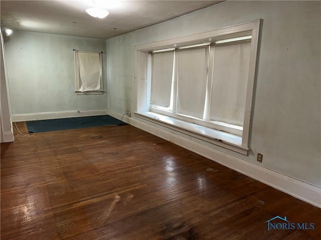 unfurnished room featuring baseboards and hardwood / wood-style flooring