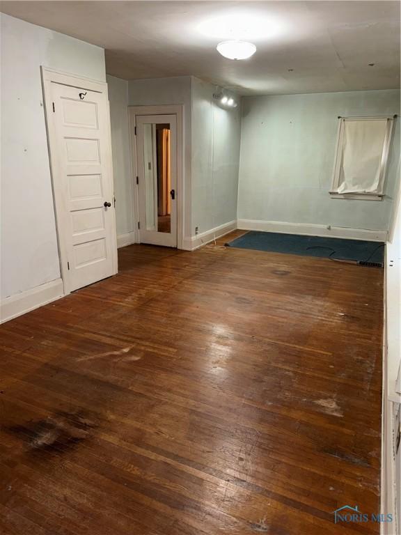 unfurnished room featuring baseboards and hardwood / wood-style flooring