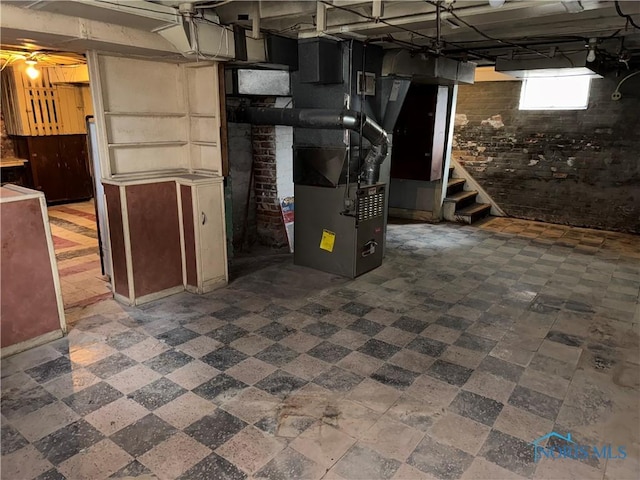 basement featuring stairs and heating unit