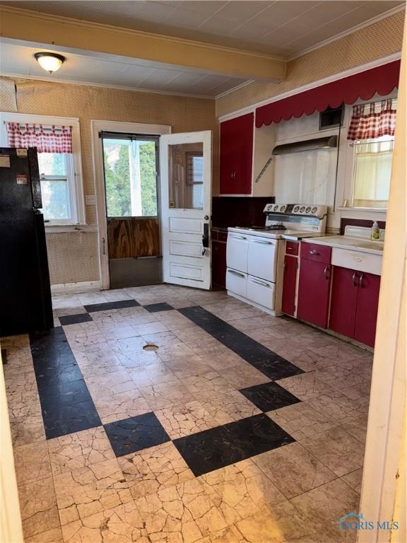 kitchen featuring red cabinetry, beamed ceiling, white electric range oven, freestanding refrigerator, and wallpapered walls