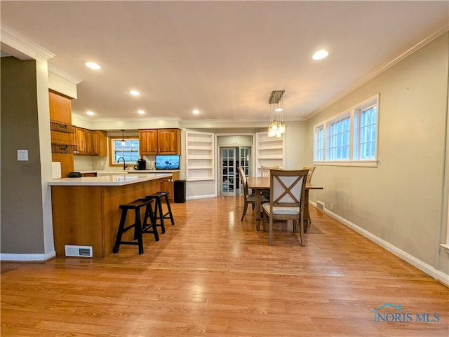 509 Oakwood Ave, Bryan, OH 43506 - dining room with light wood-style flooring, ornamental molding, baseboards, and visible vents