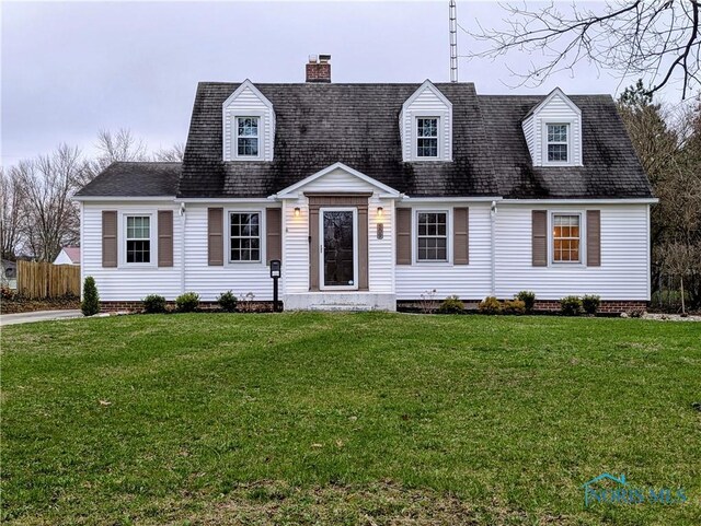 509 Oakwood Ave, Bryan, OH 43506 - cape cod home featuring a chimney, fence, a shingled roof, and a front yard