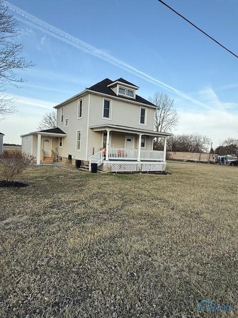 view of front of home with covered porch and a front lawn