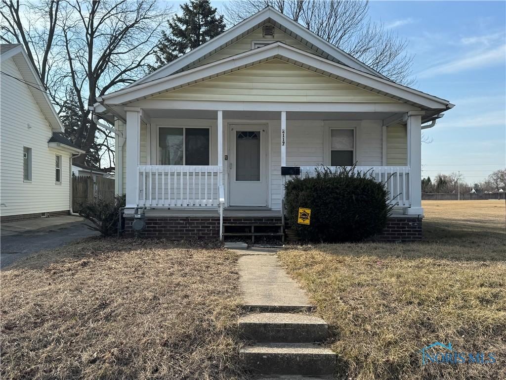 view of front of home featuring covered porch and a front lawn